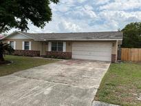 Charming single-story home with a well-maintained lawn, brick accents, and an attached two-car garage at 2841 Beal St, Deltona, FL 32738