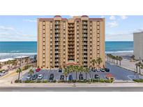 Oceanfront condo building with a parking lot lined with palm trees and direct beach access at 3145 S Atlantic Ave # 503, Daytona Beach Shores, FL 32118