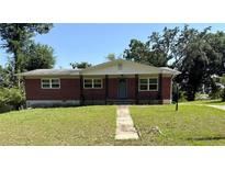 Charming brick home with a welcoming front porch and a well-manicured lawn at 404 Brentwood Ave, Deland, FL 32724