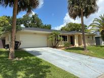 Charming single-story home featuring a spacious driveway, two-car garage, and well-maintained landscaping with palm trees at 516 Hickorywood Ave, Altamonte Springs, FL 32714