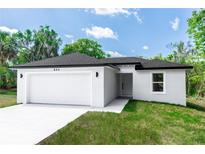 Charming single-story home with a two-car garage, fresh landscaping, and a well-manicured lawn at 544 E Voorhis Ave, Deland, FL 32724