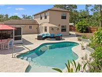 Inviting backyard pool with lush landscaping and cozy outdoor seating area, perfect for relaxation and entertaining at 5496 S Nova Rd, Port Orange, FL 32127