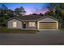 Charming single-story home featuring a well-maintained lawn and a two-car garage at dusk at 560 Sumner Ave, Orange City, FL 32763