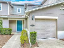 Charming townhome featuring a teal front door, one-car garage, and neat landscaping at 564 Mount Olympus Blvd, New Smyrna Beach, FL 32168