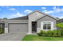 Charming single-Gathering home showcasing a two-car garage, stone accents, and well-maintained landscaping at 6212 W Fallsgrove Ln, Port Orange, FL 32128