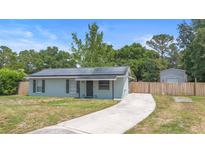 Charming single-story home featuring a well-maintained lawn, solar panels, and a long driveway at 6509 Lake Lerla Dr, Apopka, FL 32712