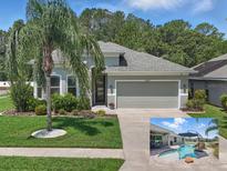Landscaped home featuring a well-manicured lawn, palm tree, and gray two-car garage at 6820 Vintage Ln, Port Orange, FL 32128