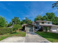 Charming two-story home with a well-maintained lawn, lush landscaping, and a concrete driveway at 834 Sugar House Dr, Port Orange, FL 32129