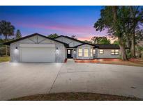 Charming single-story home boasts a manicured lawn, well-lit facade, and attached two-car garage at 9720 Fairway Cir, Leesburg, FL 34788