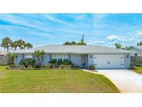 Charming single-story home with light blue exterior, well-maintained landscaping, and attached two-car garage at 114 Ocean Aire N Ter, Ormond Beach, FL 32176
