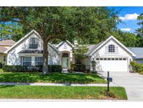 Charming single Gathering home with a large shade tree, a well-manicured lawn, and a two-car garage at 1412 Bent Oaks Blvd, Deland, FL 32724