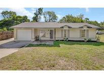 Charming single-story home with a well-maintained lawn, attached garage, and neutral-toned exterior at 1562 Monroe St, Deland, FL 32720