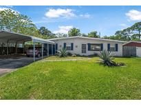 Charming single-story home featuring a carport, lush lawn, and well-maintained landscaping at 1608 Raleigh Ave, Daytona Beach, FL 32117