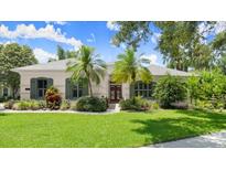 Charming home with lush landscaping, palm trees, and well-manicured lawn at 1653 Promenade Cir, Port Orange, FL 32129