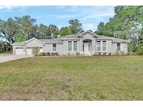 Charming single-story home with a well-maintained lawn and attached two-car garage at 2004 Quail Hollow Dr, Deland, FL 32720