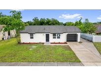 Charming single-story home with a well-manicured lawn and a driveway leading to an attached garage at 2517 Oak Hollow Dr, Kissimmee, FL 34744