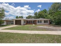 Charming single-story home with a brick and white exterior, a well-manicured lawn, and a driveway leading to an attached garage at 2842 English Dr, Deltona, FL 32738