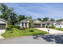 Charming single-story home with a well-manicured lawn, two-car garage, and beautifully landscaped front yard at 3026 Adrian Dr, Ormond Beach, FL 32174