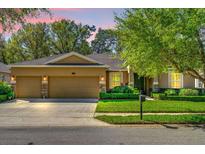 Charming home featuring a three-car garage, manicured lawn, and decorative stone accents at 320 W Victoria Trails Blvd, Deland, FL 32724