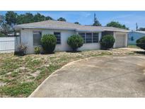 Single story home with light colored roof and rounded bushes in front of the windows at 327 Frances Ter, Daytona Beach, FL 32118