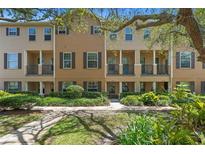 Inviting townhouse featuring a well-maintained lawn, dark shutters, and a covered front porch at 4297 Regal Town Ln, Lake Mary, FL 32746