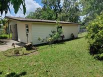 The exterior of the house is surrounded by a green yard and foliage at 4830 Kempston Dr, Orlando, FL 32812