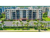 Beautiful multi-story condo building with ample parking and meticulously maintained landscaping, creating an inviting atmosphere at 5300 S Atlantic Ave # 12-403, New Smyrna Beach, FL 32169