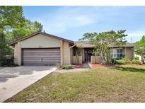 Charming single-story brick home featuring a well-maintained lawn and attached garage, creating a cozy curb appeal at 953 Tulip St, Deltona, FL 32725