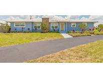 Charming single-story home with a light blue exterior, well-manicured lawn, and paved driveway at 1032 Bel Aire Dr, Daytona Beach, FL 32118
