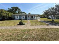 Charming single-story home featuring a cozy front porch and a convenient covered carport at 1081 Cobblestone Ave, Deltona, FL 32725