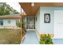 Inviting front entrance with tiled walkway, decorative wrought iron, and well-maintained landscaping at 1113 Fort Smith Blvd, Deltona, FL 32725