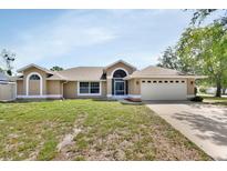 Inviting single-story home featuring a manicured lawn and attached two-car garage at 1142 Glendale Ave, Deltona, FL 32725