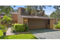 Charming home with a two-car garage, complemented by lush landscaping and mature trees at 115 Oaks Ct # 115, Sanford, FL 32771
