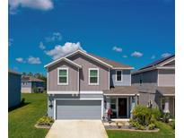 Charming two-story home with gray siding, a well-manicured lawn and inviting front entrance at 1183 Cabot Cliffs Dr, Daytona Beach, FL 32124