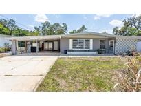 Charming single-story home with a gray exterior, carport, and well-maintained front yard at 1284 Vanderbilt Dr, Ormond Beach, FL 32174