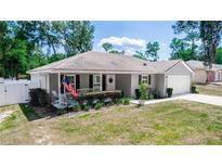 Charming single-story home with a well-manicured front lawn and a welcoming front porch area with seating at 1326 13Th St, Orange City, FL 32763