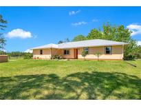 Lovely single-story home featuring a metal roof and a well-manicured lawn and a bright exterior on a sunny day at 140 Rodeo Rd, Ormond Beach, FL 32174