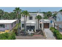Charming stucco home with palm trees, wrought iron fence, and driveway at 145 S Peninsula Dr, Daytona Beach, FL 32118