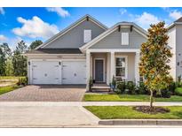 Charming home featuring a two-car garage, brick pathway, and a welcoming covered front porch at 16241 Honey Harvest St, Winter Garden, FL 34787