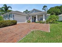 Charming single-story home with a brick driveway, manicured lawn, and a welcoming front porch at 171 Birchmont Dr, Deland, FL 32724