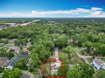 Aerial view of a home surrounded by lush greenery and trees under a bright blue sky at 200 Alpine St, Altamonte Springs, FL 32701