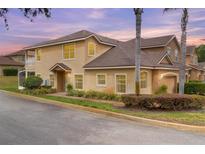 Two-story tan stucco home with lush landscaping, palm trees, and an attached two-car garage at 201 Dyson Dr, Deland, FL 32724