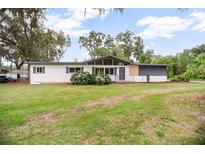 Charming single-story home with well-maintained lawn, mature trees, and neutral color palette at 2215 Lake Ruby Rd, Deland, FL 32724