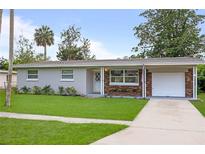Charming single-story home boasts a well-manicured lawn, brick accents, and an attached carport at 2226 Sherwood Dr, South Daytona, FL 32119