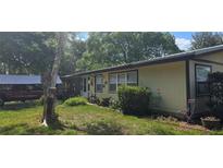Charming single-story home with a well-maintained lawn and cozy front porch at 27751 Luella Ave, Paisley, FL 32767