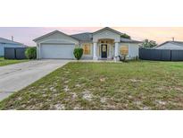 Charming single-Gathering home featuring a well-manicured lawn, inviting entry, and attached two-car garage at 2884 Sweet Springs St, Deltona, FL 32738