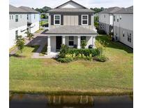 Charming two-story home with a welcoming front porch and well-manicured lawn near the water at 2916 Meleto Blvd, New Smyrna Beach, FL 32168