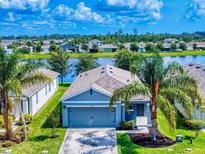 Charming one-story home with a two-car garage, lush lawn, and tropical landscaping near a lake in a friendly community at 2919 Sime St, New Smyrna Beach, FL 32168