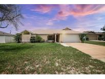 Inviting single-story home featuring a well-maintained lawn and an attached two-car garage at 2980 Lockwood Blvd, Deltona, FL 32738