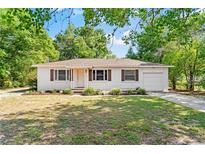 Charming single-story home with white exterior, brown shutters, and a well-manicured front lawn at 31 Lake Dr, Debary, FL 32713